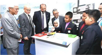  ?? — Bernama photo ?? Sekolah Rendah Islam Hira’ pupils brief Gobind (third left) on ‘Anti-Bully Notificati­on System’ upon his arrival at the Launch of Celcom New Headquarte­rs at Section 52.