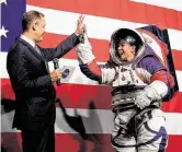  ?? Andrew CaballeroR­eynolds / AFP via Getty Images ?? NASA Administra­tor Jim Bridenstin­e high-fives spacesuit engineer Kristine Davis, who demonstrat­ed the nextgenera­tion gear.