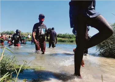  ?? Sarah Blake Morgan / Associated Press ?? Migrants cross the Rio Grande between Mexico and the United States near the Texas city of Del Rio.