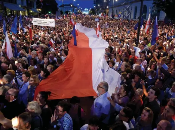  ?? ADAM CHELSTOWSK­IAFP/GETTY IMAGES ?? Protesters gather in front of the presidenti­al palace in Warsaw, Poland, as they urge the Polish president to reject a bill changing the judiciary system.