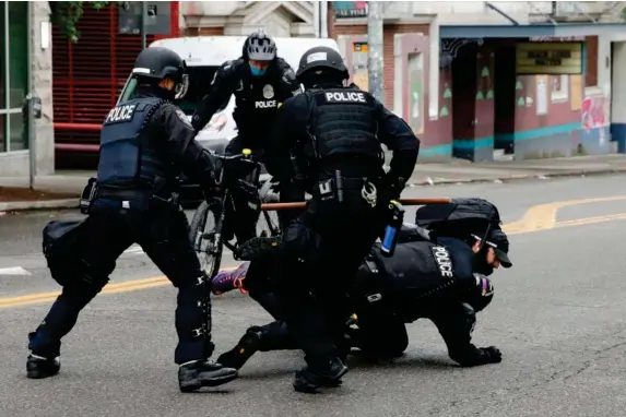  ??  ?? Police tackle a demonstrat­or to the floor at Seattle’s CHOP zone, where Independen­t reporter Andrew Buncombe was arrested (AFP via Getty)