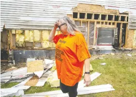  ?? ANDREW VAUGHAN / THE CANADIAN PRESS ?? Parishione­r Heather Knockwood walks past the fire-damaged exterior at St. Kateri Tekakwitha Church in Indian Brook, N.S., on Wednesday. The fire at the Catholic
church that serves the Sipekne'katik First Nation, is believed to be suspicious.