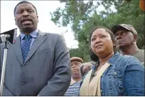  ?? Associated Press photo ?? Derrick Johnson, left, president of the Mississipp­i NAACP, talks to the media on behalf of Stacey Payton, centre right, and Hollis Payton, right.