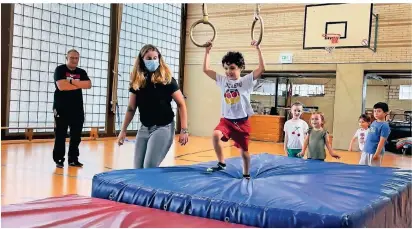  ?? FOTO: SCHALLJO ?? Die Kinder turnen in der ersten Stunde unter anderem an Ringen. Erzieherin Franziska Papen gibt Hilfestell­ung, im Hintergrun­d beobachtet Trainer Hans-Georg Focken die Übungen aufmerksam.