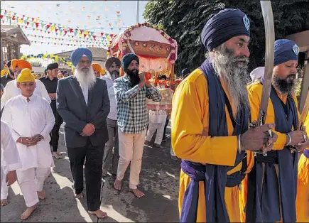  ?? SUKHWINDER ?? Singh Sidhu, in a suit, celebrates a Sikh spiritual leader’s birthday at Gurdwara Sahib, a Sikh temple in Stockton.