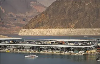  ?? John Locher / Associated Press ?? A lightersha­ded bathtub ring shows the high water line at Lake Mead near Boulder City, Nev. The U.S. Bureau of Reclamatio­n forecasts a dip of about 5 feet from levels recorded a year ago.