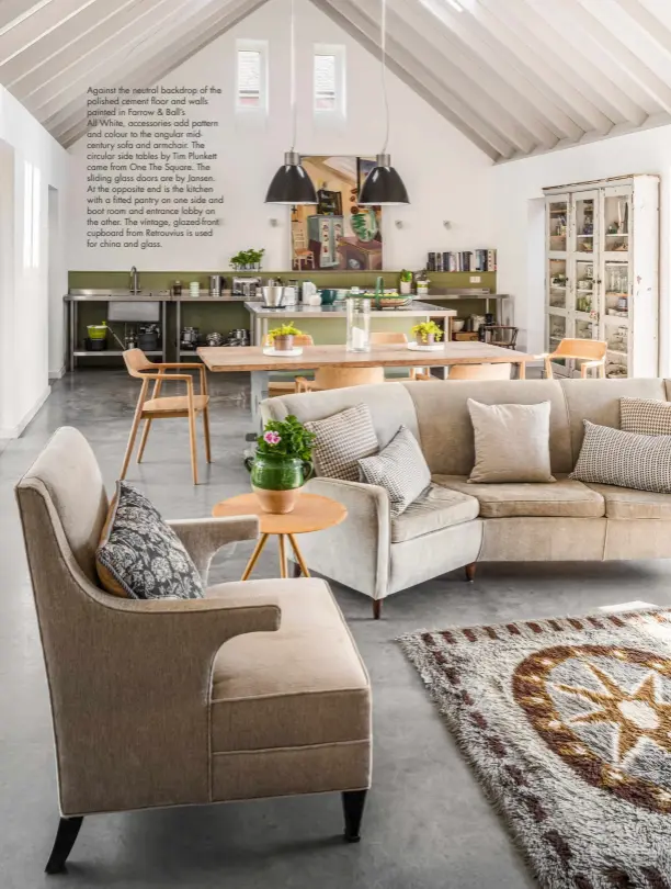  ??  ?? Against the neutral backdrop of the polished cement floor and walls painted in Farrow & Ball’s
All White, accessorie­s add pattern and colour to the angular midcentury sofa and armchair. The circular side tables by Tim Plunkett came from One The Square. The sliding glass doors are by Jansen. At the opposite end is the kitchen with a fitted pantry on one side and boot room and entrance lobby on the other. The vintage, glazed-front cupboard from Retrouvius is used for china and glass.