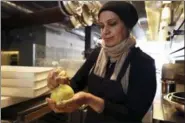  ?? LORIN ELENI GILL — THE ASSOCIATED PRESS ?? In this photo taken Muna Anaee, prepares a ball of khobz orouk, a flatbread she would eat frequently in her native Iraq, at the Tawla restaurant kitchen in San Francisco during the inaugural Refugee Food Festival.