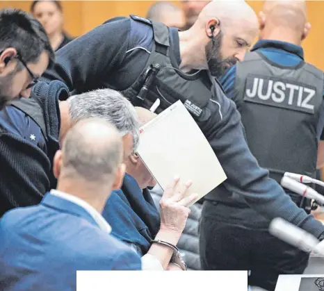  ?? FOTO: BERND WEISSBROD/DPA ?? Angeklagte der Reuß-Gruppe am Montag mit Justizbeam­ten am Stuttgarte­r Oberlandes­gericht. Verhandelt wird im Hochsicher­heitsberei­ch des Gefängniss­es in Stuttgart-Stammheim.