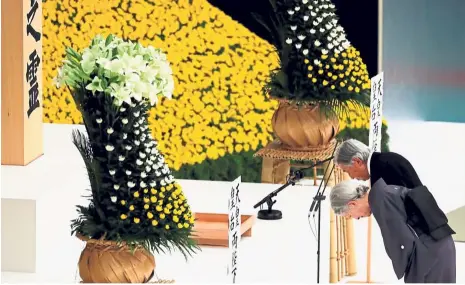  ?? — Reuters ?? Never forget: Akihito and Michiko bowing at an altar during a moment of silence to the war dead at a ceremony marking the 73rd anniversar­y of Japan’s surrender at Budokan Hall in Tokyo.
