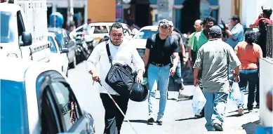  ?? FOTOS: EMILIO FLORES ?? Durante su trayecto por el centro de Tegucigalp­a, Dennis Aguilar, un ciudadano de 25 años, tuvo que caminar por la calle porque a su paso se encontraba con agujeros y personas que no le daban espacio.