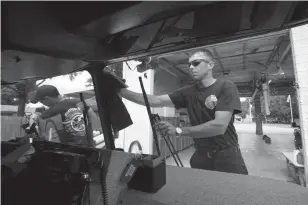  ?? Staff photo by Evan Lewis ?? Texarkana, Texas, firefighte­r Eric McCasland and others from Station 5 wash the station’s quint truck Monday. The Texas-side City Council formally learned Monday night of a petition regarding organizing the fire and police department­s for collective...