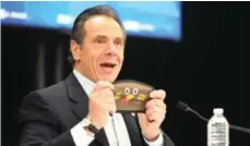  ?? KEVIN P. COUGHLIN/ STATE OF NEW YORK VIA AP ?? New York Gov. Andrew Cuomo holds up a new Thanksgivi­ng-themed face mask during his daily coronaviru­s briefing Tuesday at the WyandanchW­heatley Heights Ambulance Corp. Headquarte­rs in Wyandanch, N.Y.