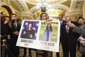  ?? MARK SCHIEFELBE­IN / AP ?? Sen. Joni Ernst (R-iowa) holds a poster showing murder victims Sarah Root and Laken Riley on Capitol Hill on Feb. 27. House Republican­s highlighte­d their deaths with the passage of the “Laken Riley Act.”