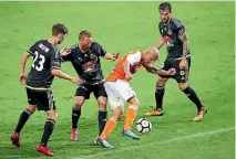  ??  ?? Wellington Phoenix defenders surround Brisbane Roar striker Massimo Maccarone on Saturday night.