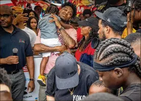  ?? PHOTOS BY STEVE SCHAEFER / SPECIAL TO THE AJC ?? Attendees surround rapper 21 Savage as he arrives Sunday at the fourth annual Issa Back 2 School Drive in Decatur.