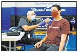  ?? Ellen Schmidt Las Vegas Review-journal @ellenschmi­dttt ?? Christian Hyderkhan gives a Pfizer COVID-19
shot to Edwin Guerrero at a Southern Nevada Health District vaccinatio­n clinic June 1 at Desert Pines High School.