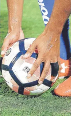  ??  ?? ► El balón en las manos de un futbolista.