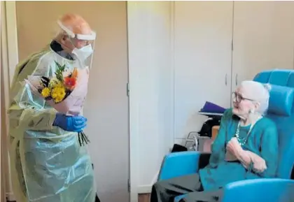  ?? ?? John Carter, in full PPE, about to give some flowers to his delighted wife Mary.