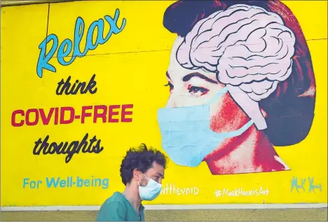  ?? JEFF CHIU/AP PHOTO ?? A masked man walks under a sign that reads “Relax think COVID free thoughts” Saturday during the coronaviru­s outbreak in San Francisco.