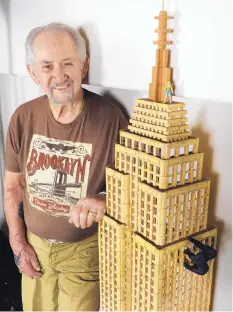  ??  ?? Brooklyn native Bill Falkenthal poses near the Empire State Building he constructe­d out of wine bottle corks. A whimsical King Kong and Fay Wray complete the creation.