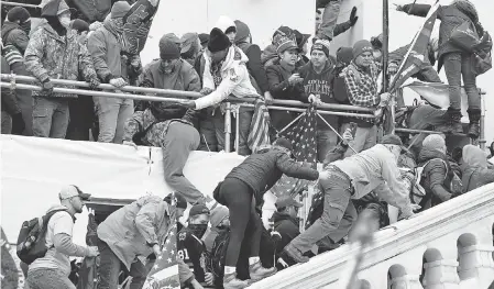  ?? JACK GRUBER/ USA TODAY ?? Rioters scale the exterior of the U. S. Capitol after a speech by President Donald Trump on Wednesday.