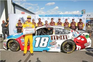  ??  ?? Kyle Busch, driver of the (18) M&M’s Red, White, & Blue Toyota, with the Coors Light Pole Award after qualifying in the pole position for the Monster Energy NASCAR Cup Series Axalta presents the Pocono 400 at Pocono Raceway in Long Pond, Pennsylvan­ia,...