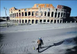  ?? AFP ?? A man walks his dog in front of the Colosseum in Rome, Italy.