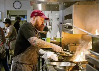  ?? REANN HUBER PHOTOS / REANN.HUBER@AJC.COM ?? Kevin Gillespie, chef and partner with Red Beard Restaurant­s group, prepares a dish for the dinner crowd at Gunshow for the restaurant’s fifth anniversar­y on Tuesday.