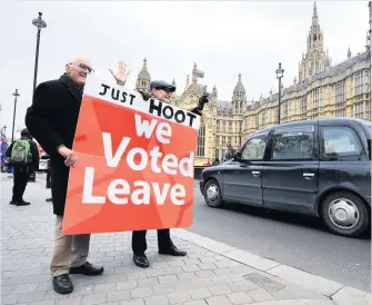  ??  ?? LEAVE MEANS LEAVE: Brexit supporters hold a placard outside the Houses of Parliament.