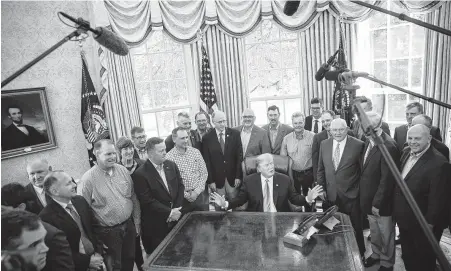  ?? Sarah Silbiger / Bloomberg ?? President Donald Trump sits for a photograph with farmers and ranchers in the Oval Office on Thursday, when he unveiled a $16 billion bailout for those hurt by his trade war with China. The trade war could damage the U.S. economy and his re-election chances.