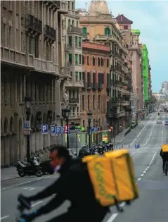  ??  ?? Trabajador­es de Glovo en una calle vacía de la capital catalana