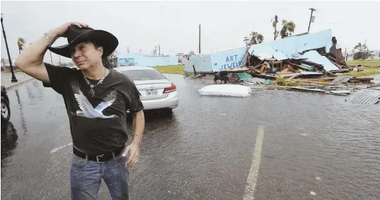  ?? AP PHOTOS ?? GULF COAST FURY: Residents of Galveston, Texas, take to an all-terrain vehicle, top, to get through the city’s flooded streets yesterday, while Ruben Sazon holds his hat while walking away from his destroyed business in Rockport, Texas.