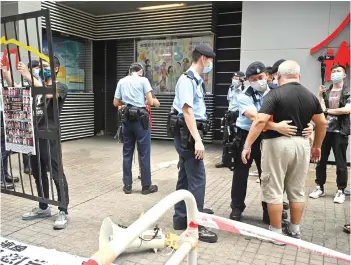  ?? — AFP photos ?? A protester (right) is searched by police as Hong Kong’s political elite began selecting a powerful committee.