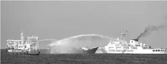  ?? AFP / Jam Sta Rosa ?? This photo taken on March 5, 2024 shows China Coast Guard vessels deploying water cannons at the Philippine military chartered Unaizah May 4 (C) during its supply mission to Second Thomas Shoal in the disputed South China Sea.