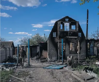  ?? ?? En ukrainsk soldat passerar en förstörd bostad i Charkivreg­ionen.