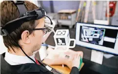  ??  ?? Ein Mitarbeite­r der Fraunhofer-Gesellscha­ft testet eine Augmented-Reality-Brille, die Ärzten bei Tumoropera­tionen helfen soll.