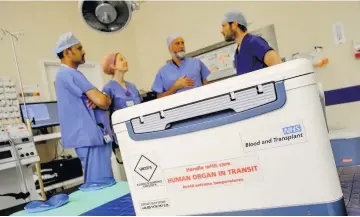  ?? An organ donation box arriving at hospital for a transplant; inset, a donor card ??