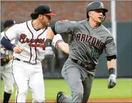  ?? ASSOCIATED PRESS ?? ARIZONA DIAMONDBAC­KS’ NICK AHMED (13) is tagged out in a rundown by by Atlanta Braves shortstop Dansby Swanson during the third inning of a baseball game Friday in Atlanta.