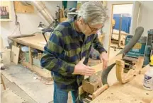  ?? BALTIMORE SUN STAFF ?? Gary Flowers, a Baltimore-based luthier, uses steam to carefully bend a strip of maple that will become the sides of a jazz guitar.