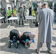  ??  ?? Demonstrat­ive Weigerung: Einige Muslime wollten nicht durch die Metalldete­ktoren gehen, um zur Al-Aksa-Moschee zu gelangen – und beteten kurzerhand auf der Straße.