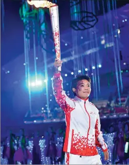  ?? XINHUA ?? Soccer star Wang Shuang takes part in the torch relay at the opening ceremony of the 7th Military World Games in Wuhan, Hubei province, on Friday.