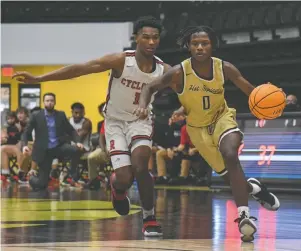  ?? The Sentinel-Record/Grace Brown ?? Hot Springs’ Nasir Hannah (0) drives the ball as Russellvil­le’s Donyae May (1) defends during Tuesday’s first-round game in the Class 5A state basketball tournament at Hot Springs.