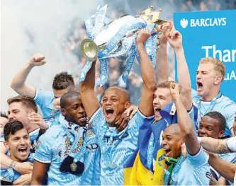  ?? — AFP photo ?? Manchester City’s Belgian midfielder Vincent Kompany (C) celebrates with the Premiershi­p trophy after his team won 2-0 during the English Premier League football match between Manchester City and West Ham United at the Etihad Stadium in Manchester on...