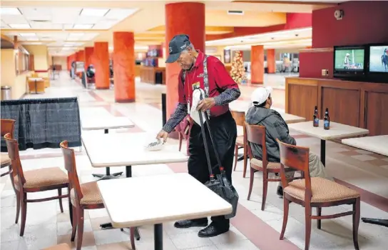  ?? PHOTO BY SARAH PHIPPS, THE OKLAHOMAN ?? Delmar Hopkins, 105, cleans tables earlier this month at Remington Park in Oklahoma City .