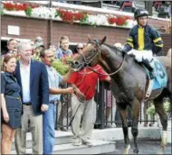  ??  ?? Long On Value, with jockey Joel Rosario up, poses for a photo in the winner’s circle after victory in the Lucky Coin Stakes Monday at Saratoga Race Course.