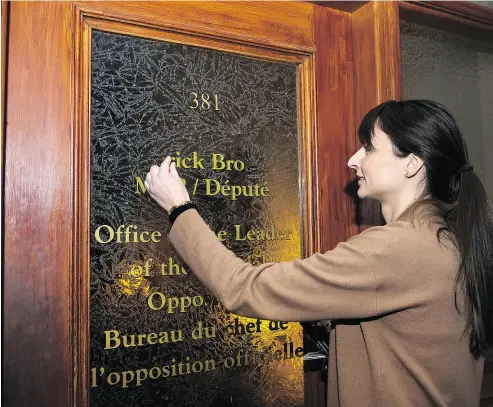  ?? NATHAN DENETTE / THE CANADIAN PRESS ?? A Queen’s Park legislativ­e staff member takes down former PC leader Patrick Brown’s office name on Friday.