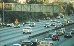  ?? ?? Motorists stop and watch as police cars pursue the Ford Bronco driven by Al Cowlings, carrying fugitive murder suspect OJ Simpson, on June 17, 1994 on the 405 freeway in Los Angeles.