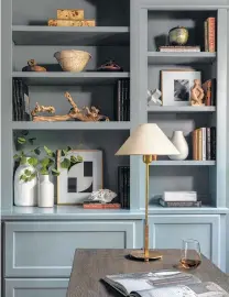  ??  ?? Books, mementoes and artwork mix on these shelves in an inhome office.