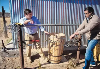  ?? MARLA BROSE/JOURNAL ?? Eric Abeita, left, and Mahad Ahmed demonstrat­e how they apply pressure to cinch wooden staves into a barrel using their homemade “closing apparatus.” The duo recently started what they say is the state’s only cooperage.